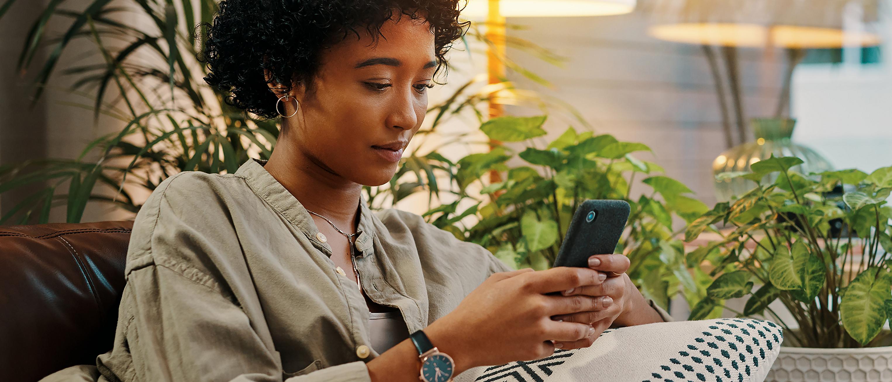 An owner sits on the couch and texts with a Ford Advisor