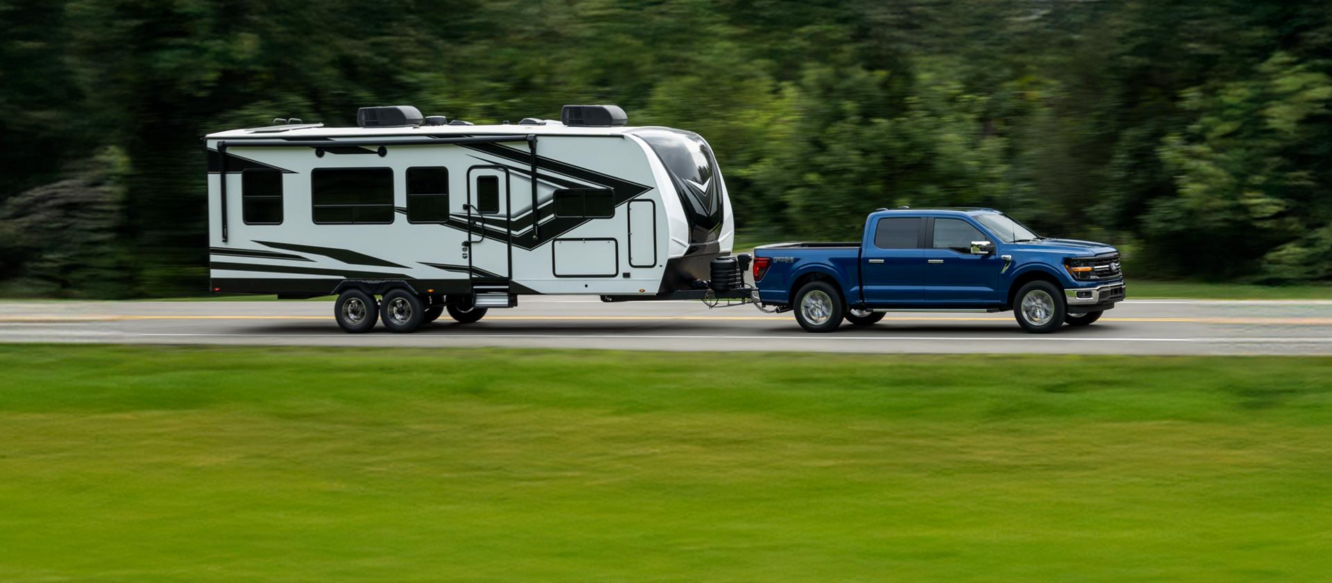 An F-150 towing a trailer on a highway.