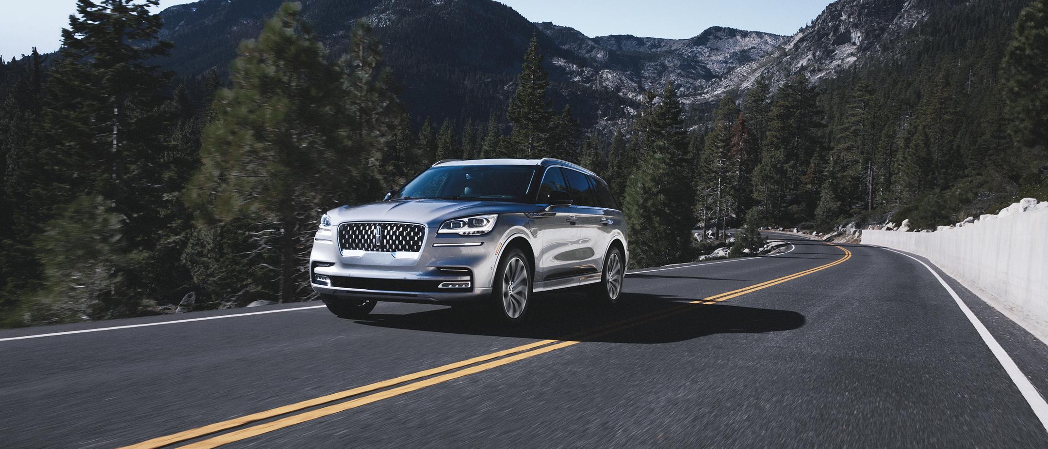 A Lincoln Aviator® SUV drives through a mountainous highway