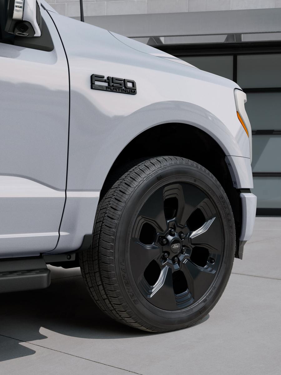 A close-up of the 22-inch aluminum wheels on a 2025 Ford F-150® Lightning® pickup with the available Dark Elements package