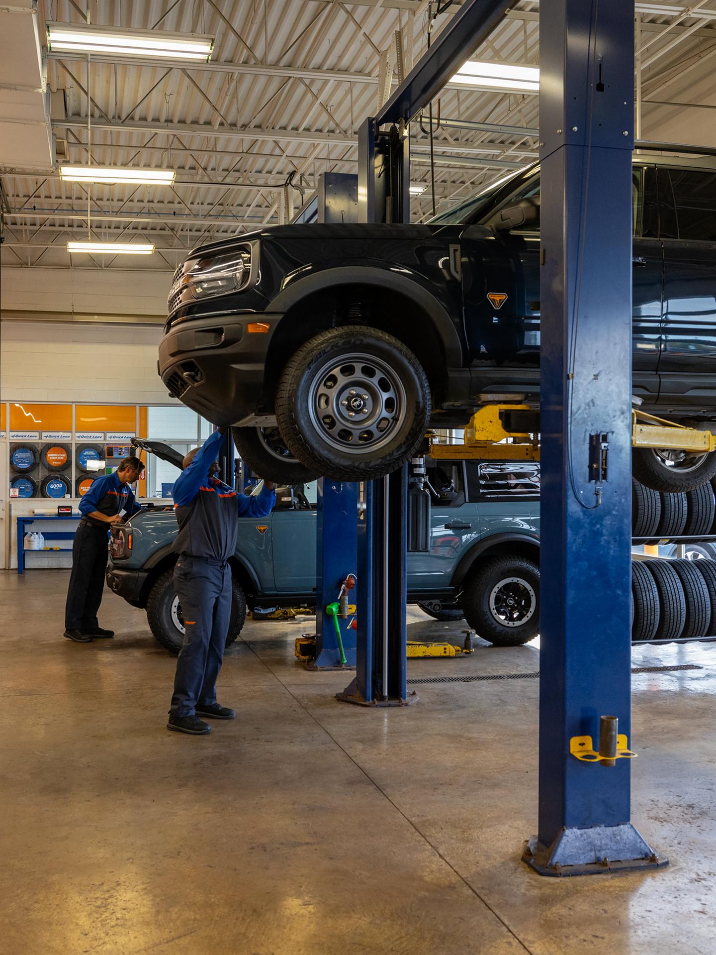 A couple Ford vehicles are being worked on in a Ford collision center