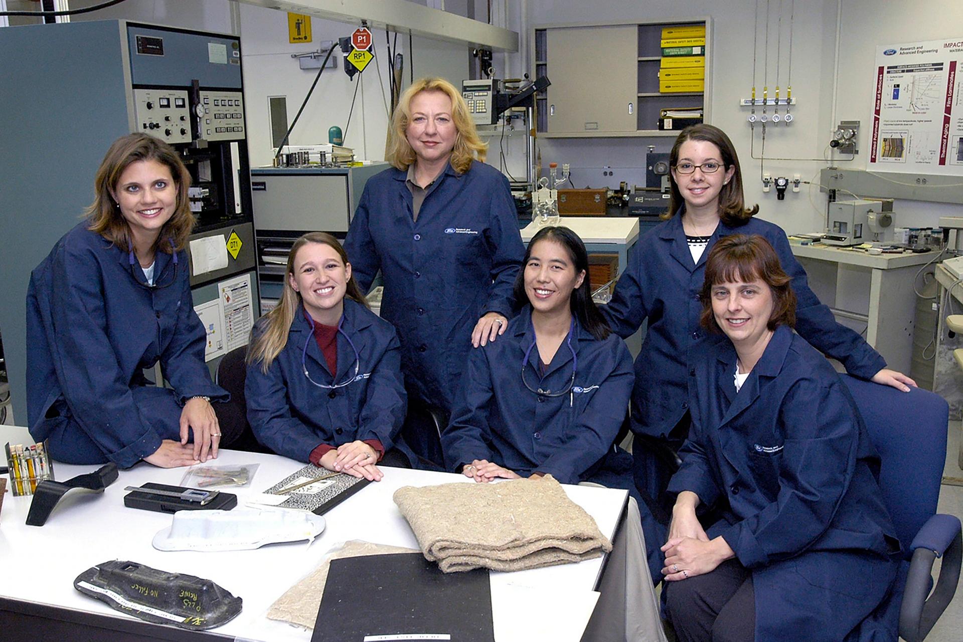 A group of women scientists are sitting around a work area