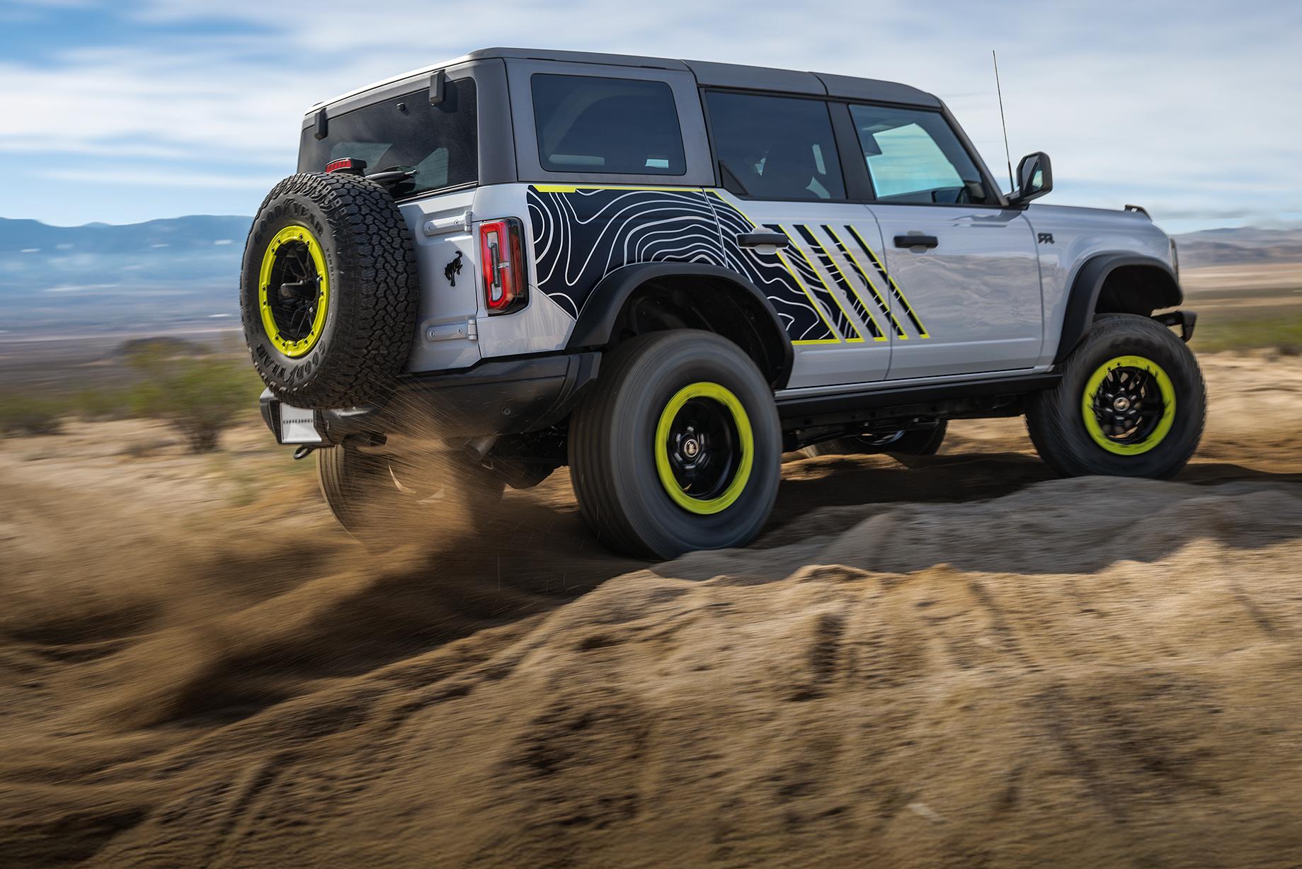 A 2027 Ford Bronco® RTR model kicking up dirt near a large rock pile