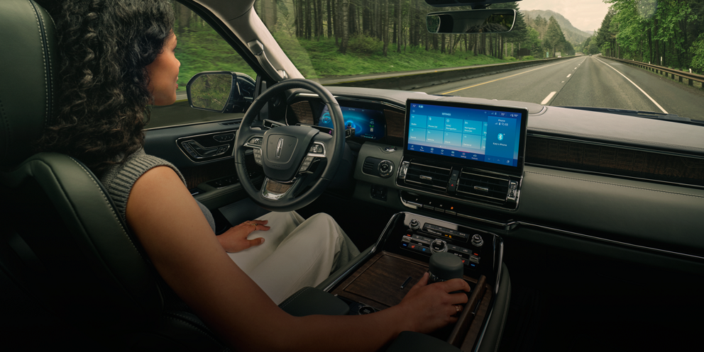 A driver of a 2023 Lincoln Black Label Navigator® SUV relaxes with hands-free driving technology engaged.