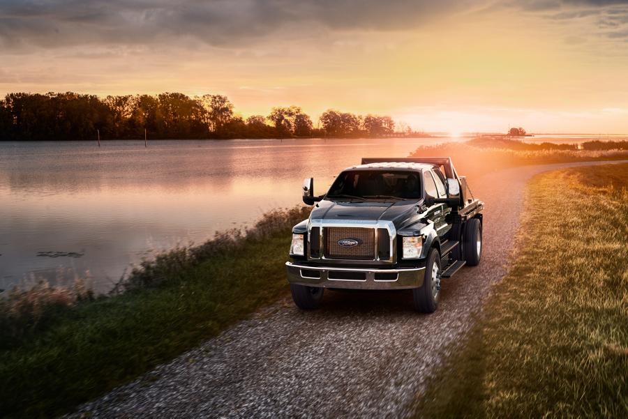 2026 Ford F-750® Crew Cab in Agate Black with utility stake bed upfit being driven near a lake