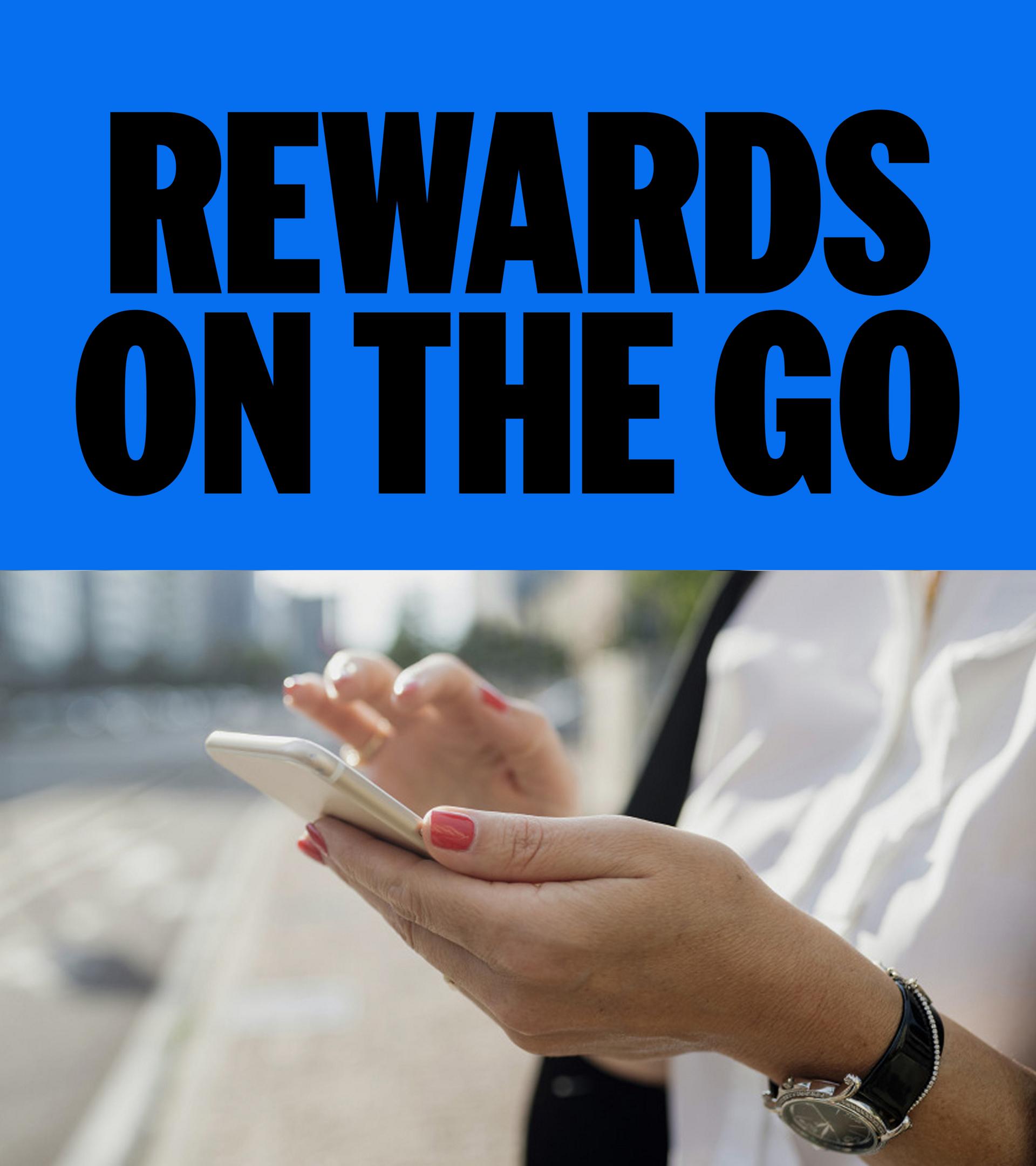 Person standing outdoors in a city, holding and using a smartphone