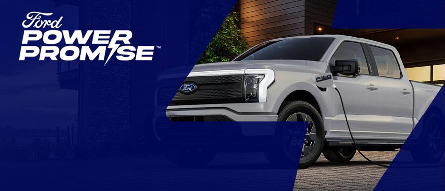 Ford Power Promise. F-150 Lightning parked in a residential driveway and plugged into a home charger.