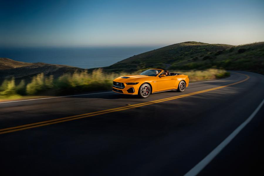 Two people driving a 2026 Ford Mustang® GT convertible on a highway
