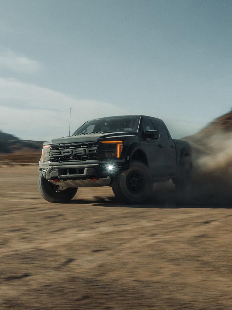 2027 Ford F-150® Raptor R™ truck being driven in the desert kicking up cloud of sand