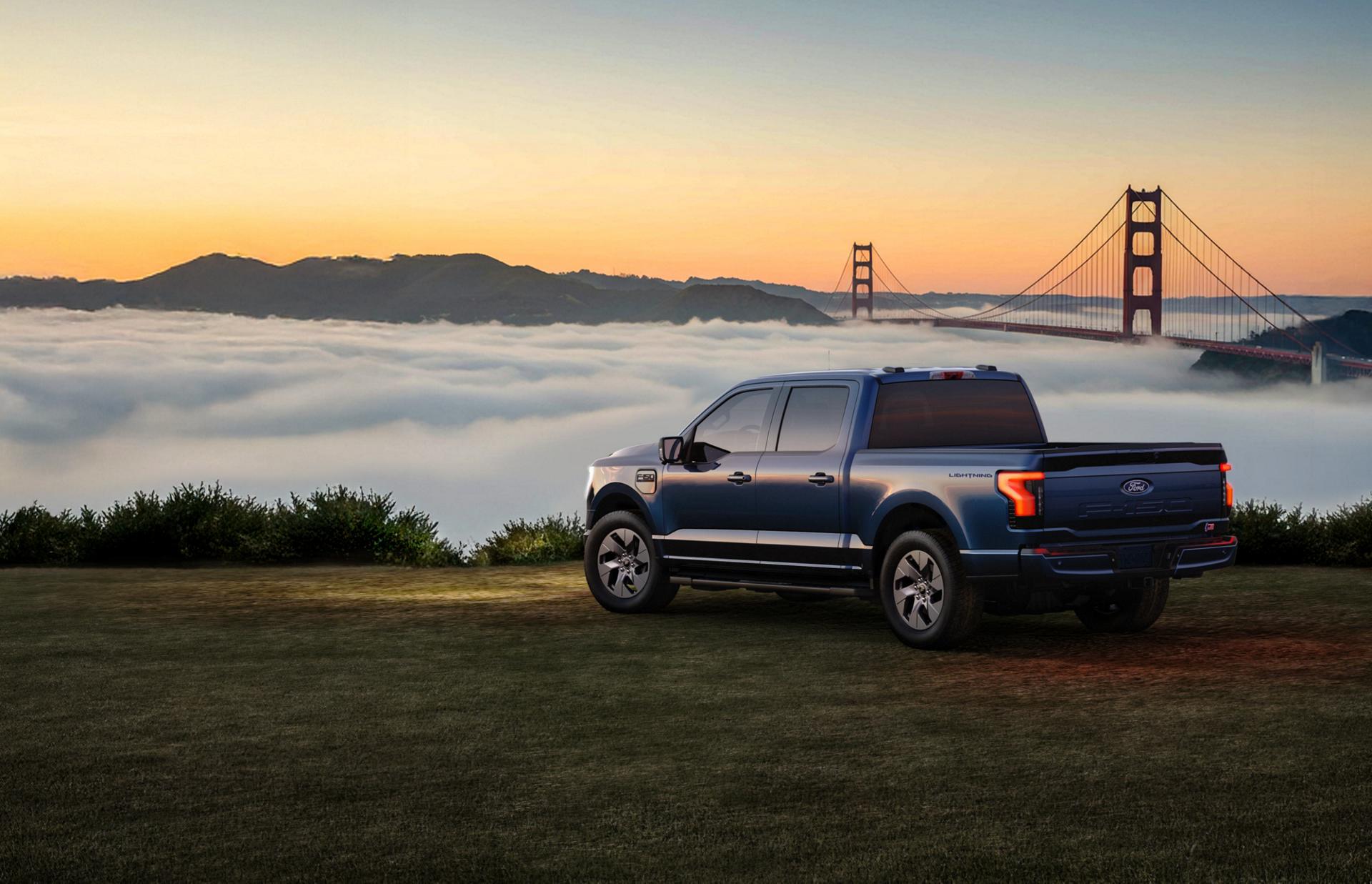 2025 Ford F-150 Lightning truck parked on grassy area overlooking a bay filled with clouds
