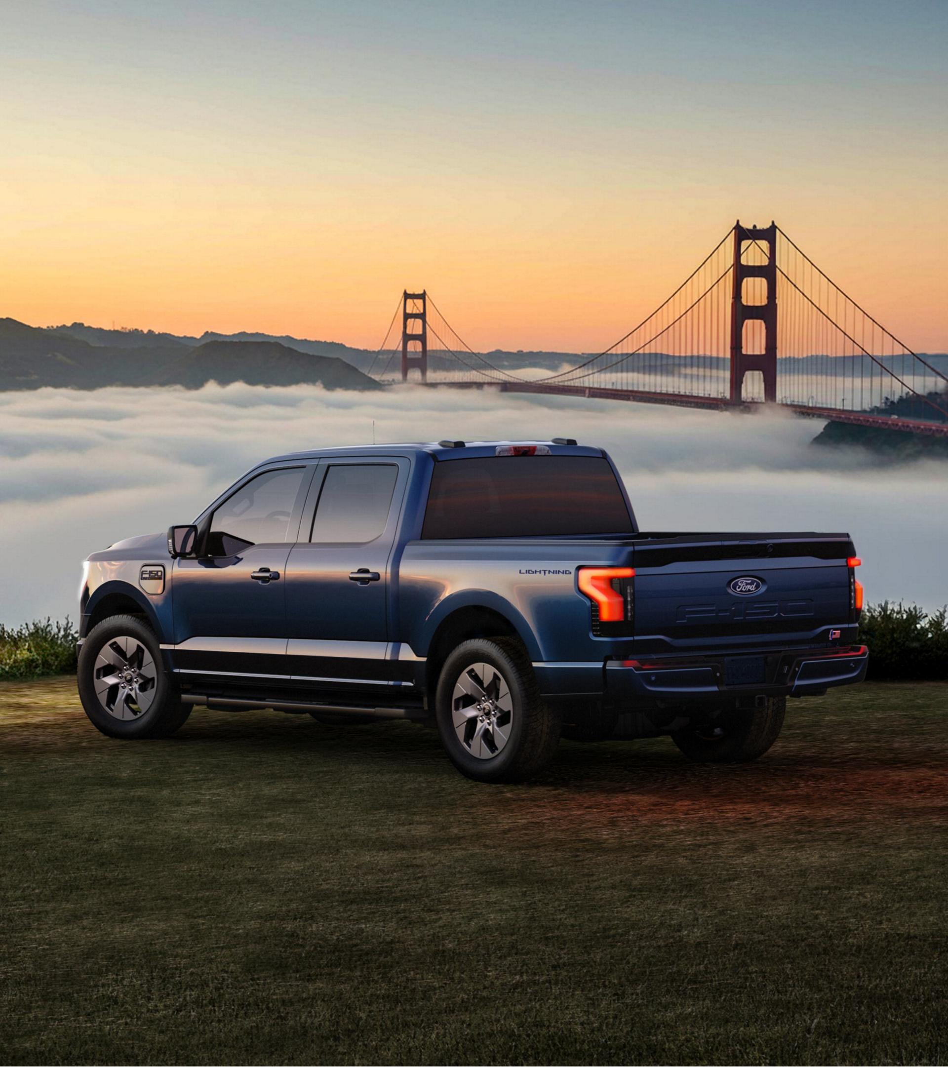 2025 Ford F-150 Lightning truck parked on grassy area overlooking a bay filled with clouds