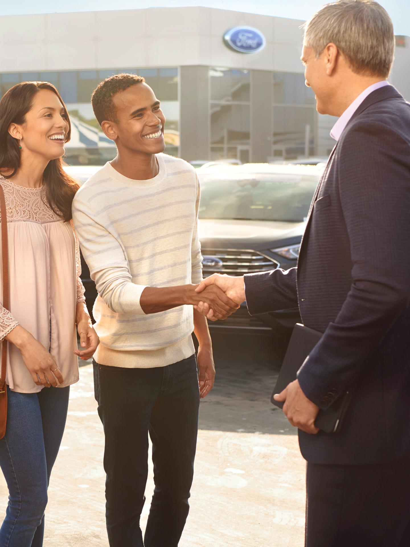 A couple speaking to a Ford technician. 