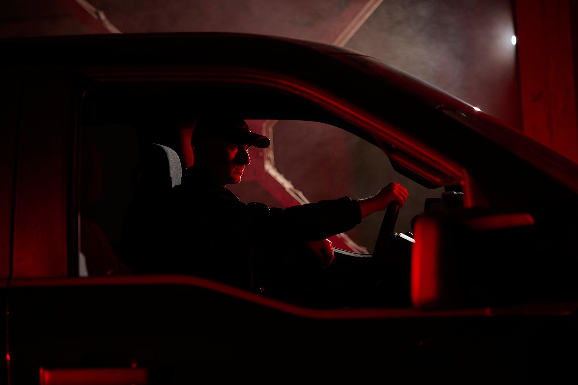 A man is sitting inside an Ford F-150® with his hand on steering wheel