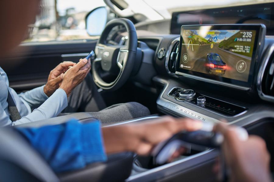 Two people sit parked in their Ford vehicle and play a video game on the centre screen.