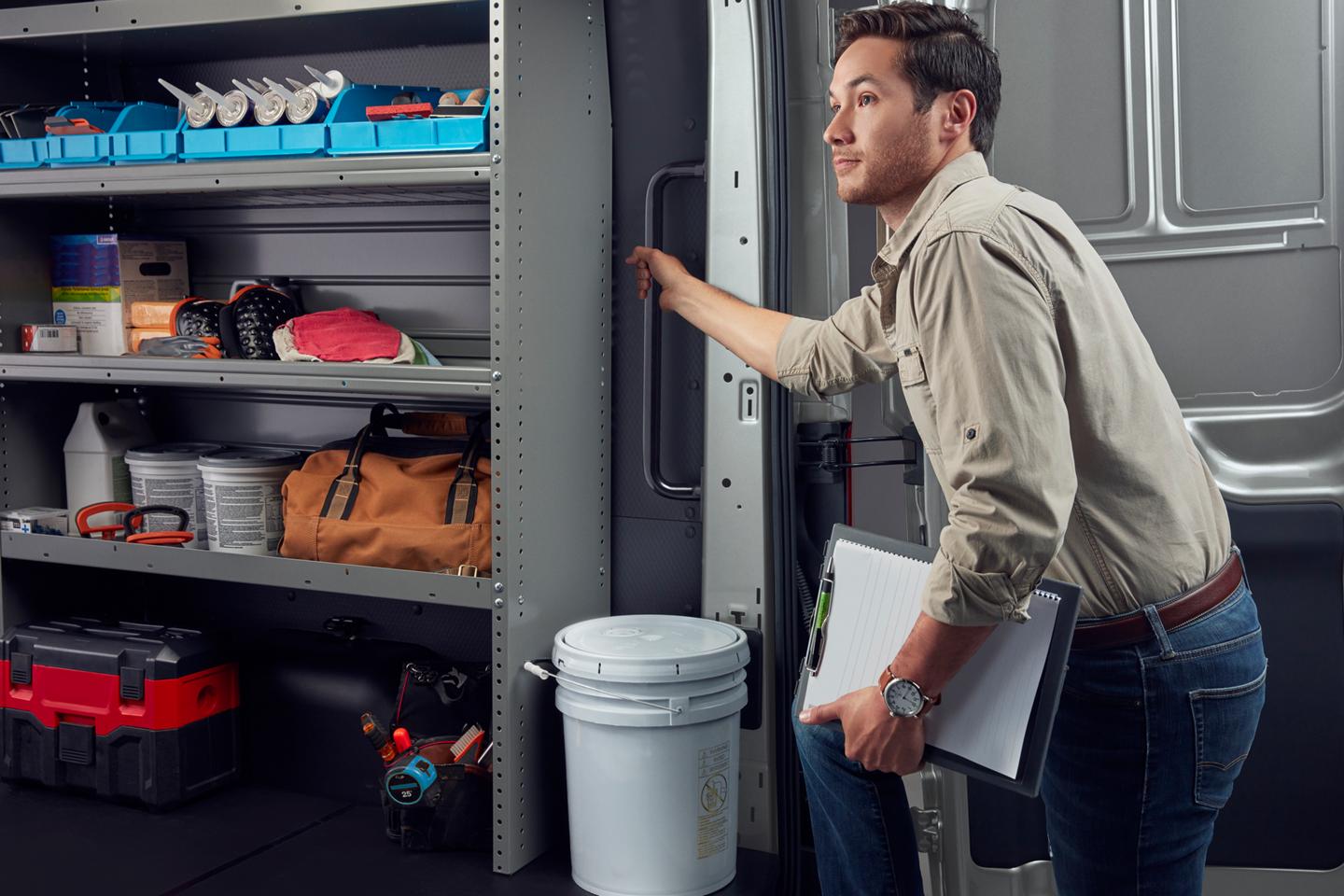 A trades person entering the rear doors of a 2026 Ford Transit® van