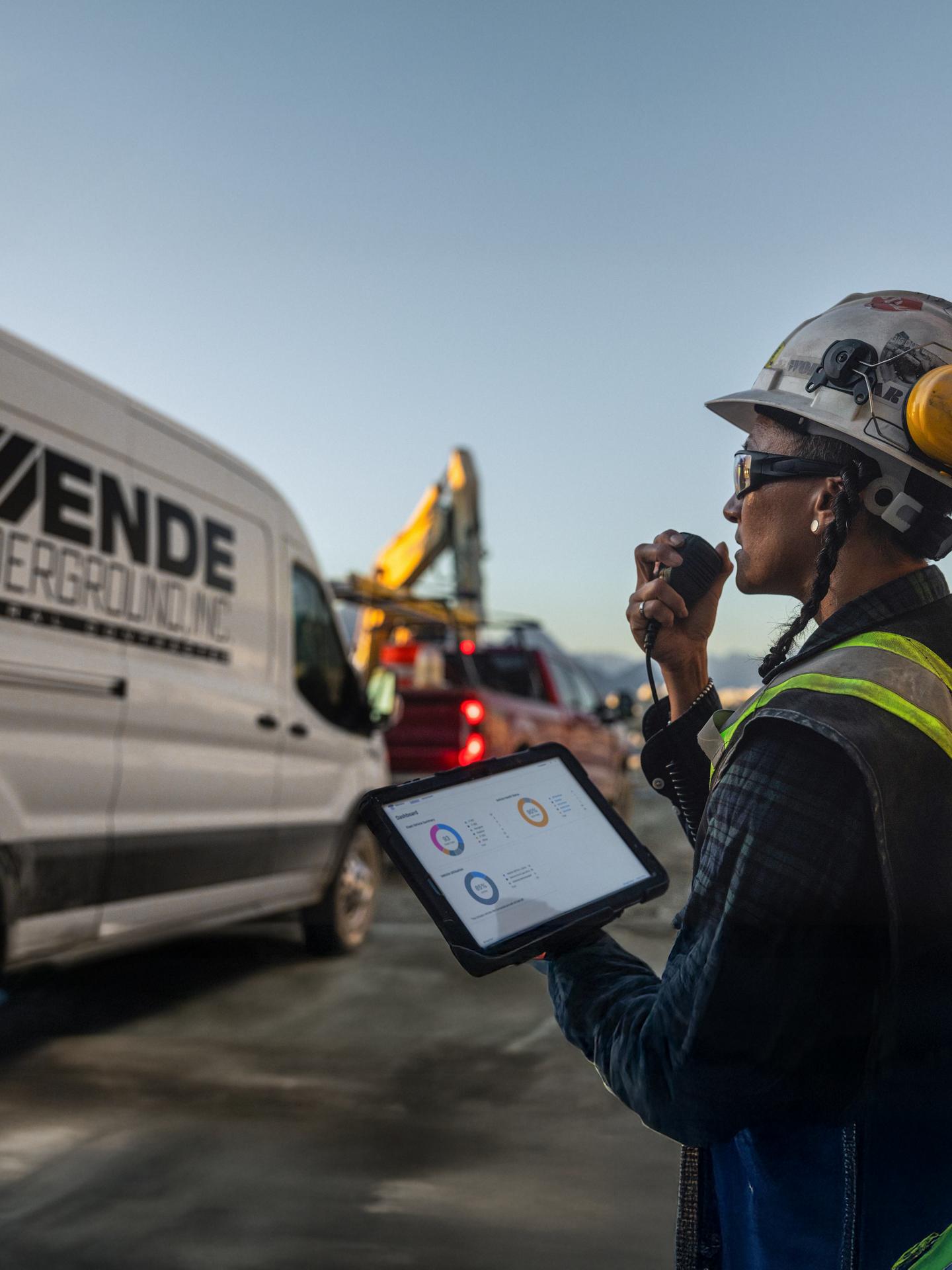 Imagen de una trabajadora de la construcción rastreando la actividad de un vehículo en un sitio de construcción comercial usando Ford Pro Telematics en un tablet.