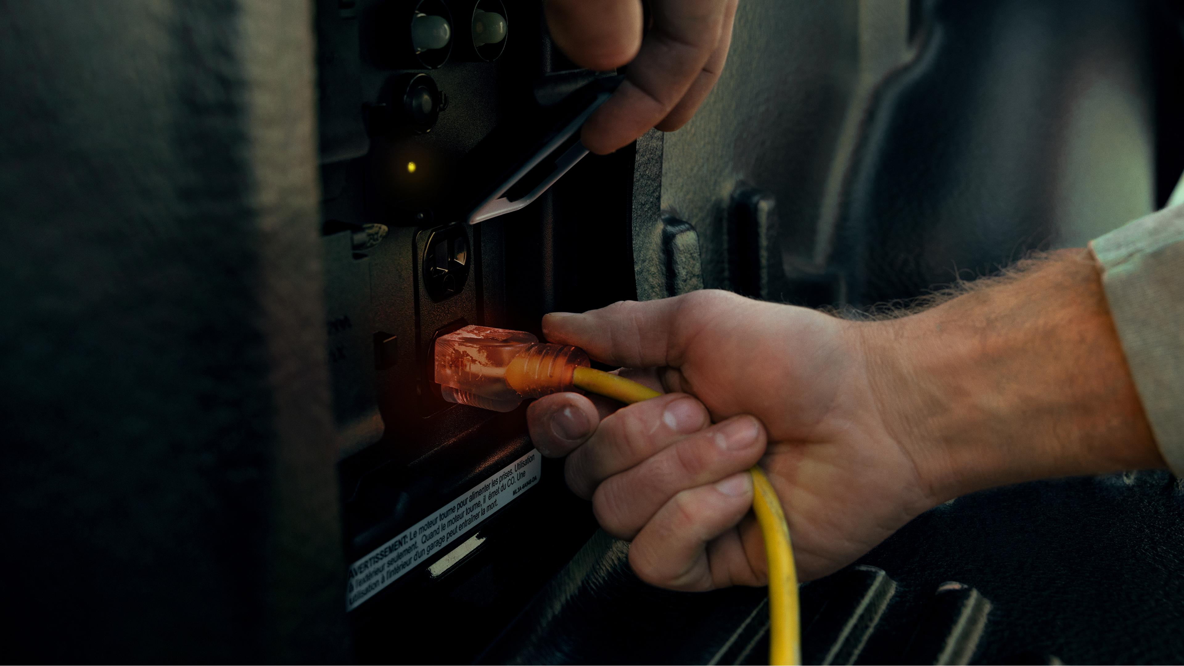 Close-up of person's hand plugging a cord into the Pro Power Onboard™ feature on an 2026 Ford F-150® truck