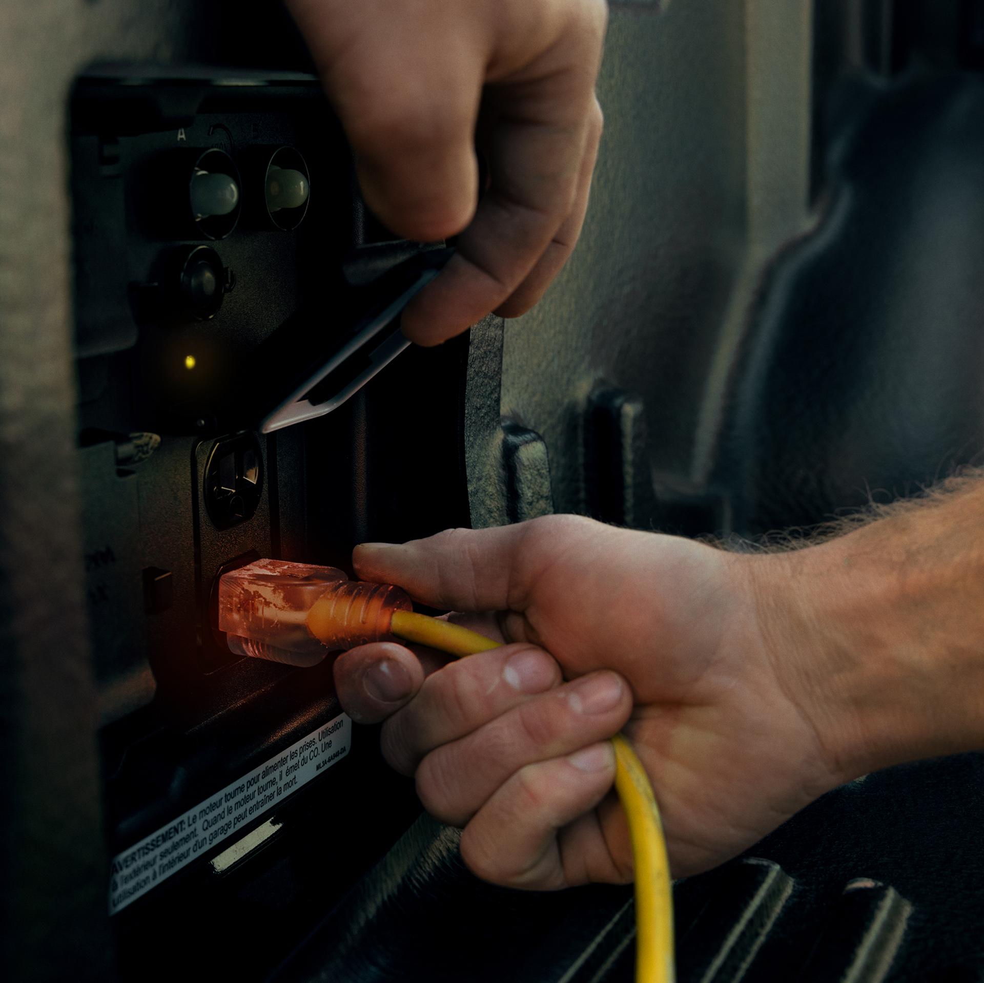 Close-up of person's hand plugging a cord into the Pro Power Onboard™ feature on an 2026 Ford F-150® truck