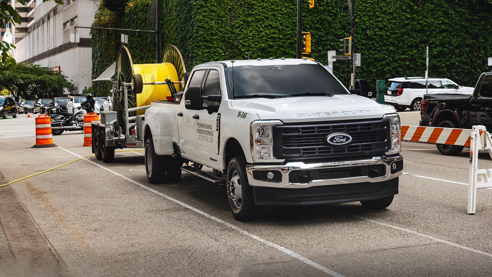 2025 Ford Super Duty® sitting in a parking lot pulling a trailer with work supplies