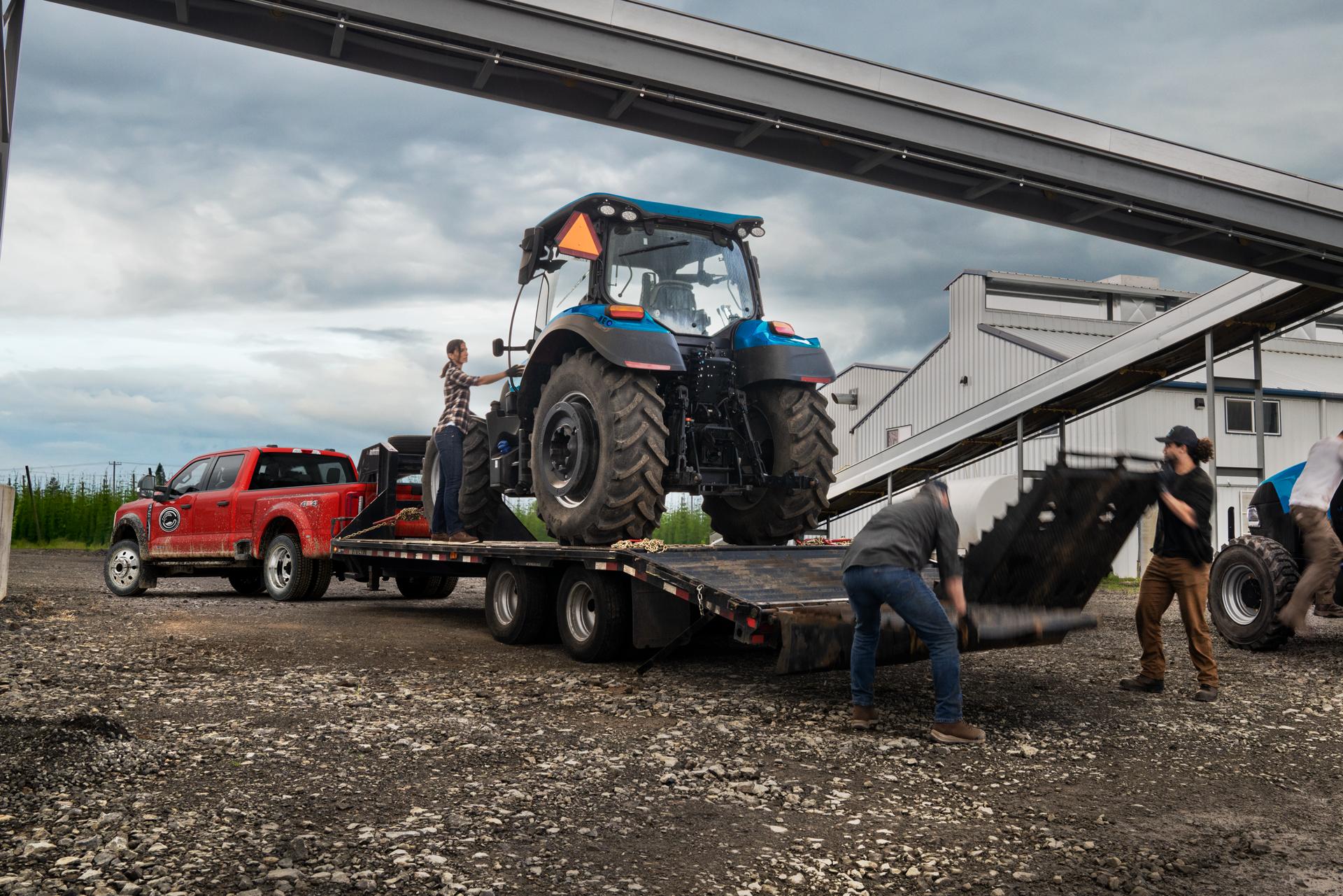 2026 Ford Super Duty® F-450® XL pickup in Race Red pulling a trailer carrying a large tractor
