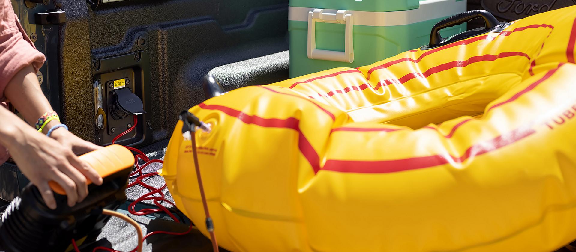 Person using the Pro Power - 400 watt outlet feature to inflate a floatation tube