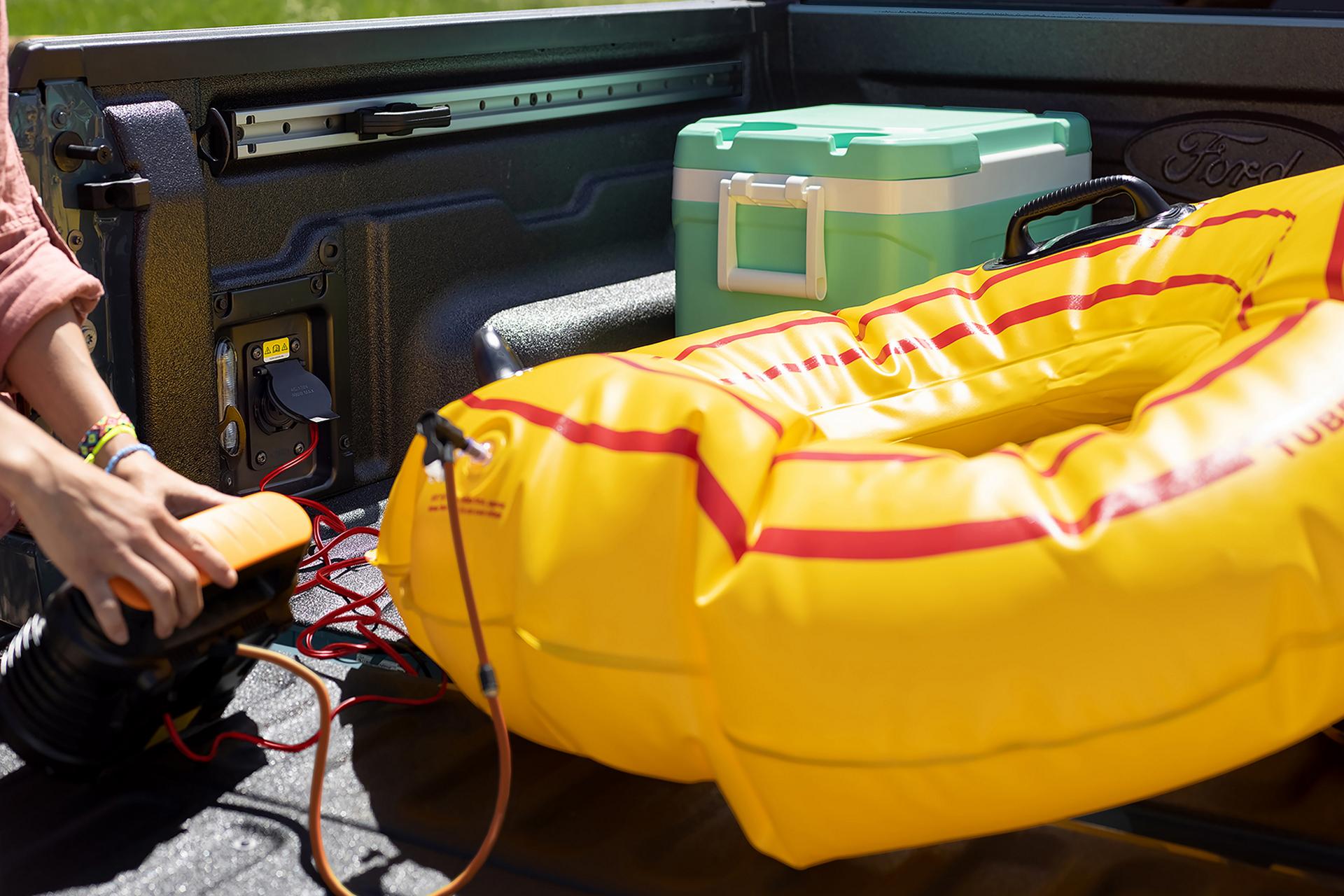 Person using the Pro Power - 400 watt outlet feature to inflate a floatation tube
