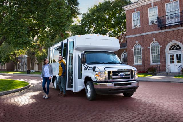 Des gens sortent d’un fourgon tronqué Ford série E 2025 avec carrosserie de bus-navette