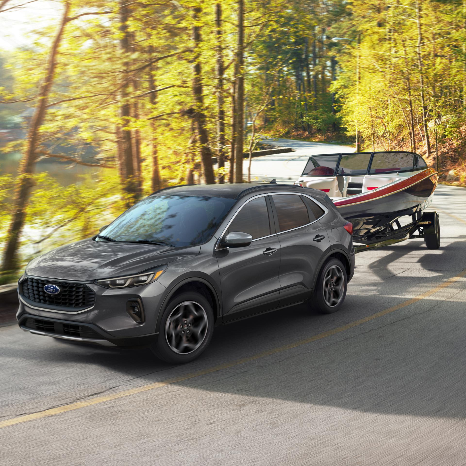 2026 Ford Escape® with 2.0L EcoBoost® engine towing a boat on a tree-lined road