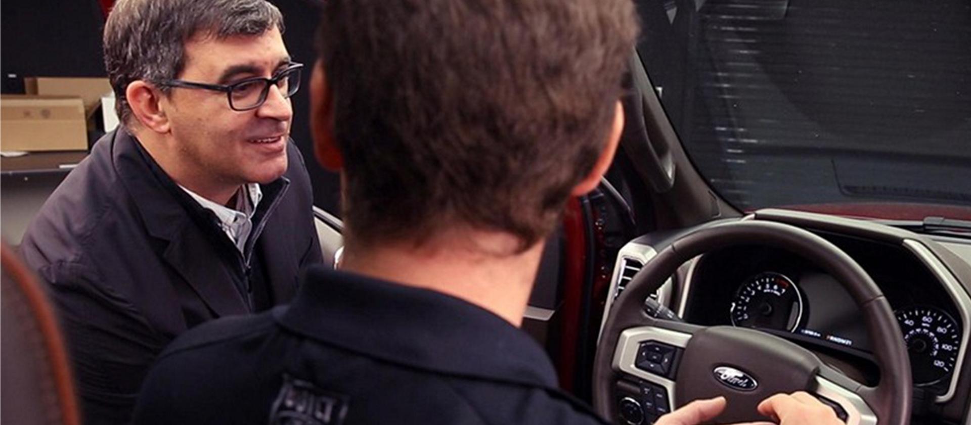 Ford employees inspect the interior of a Ford vehicle