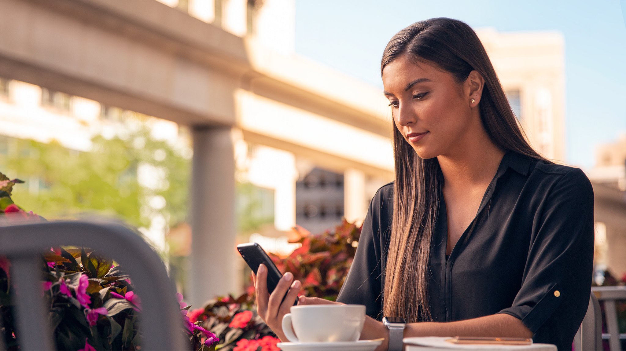 A woman outside checking her phone.