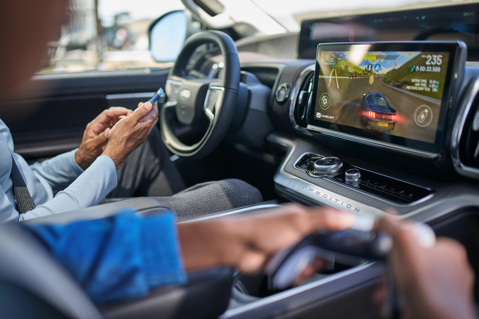 A passenger plays video games on the center display of a parked Ford Expedition® SUV