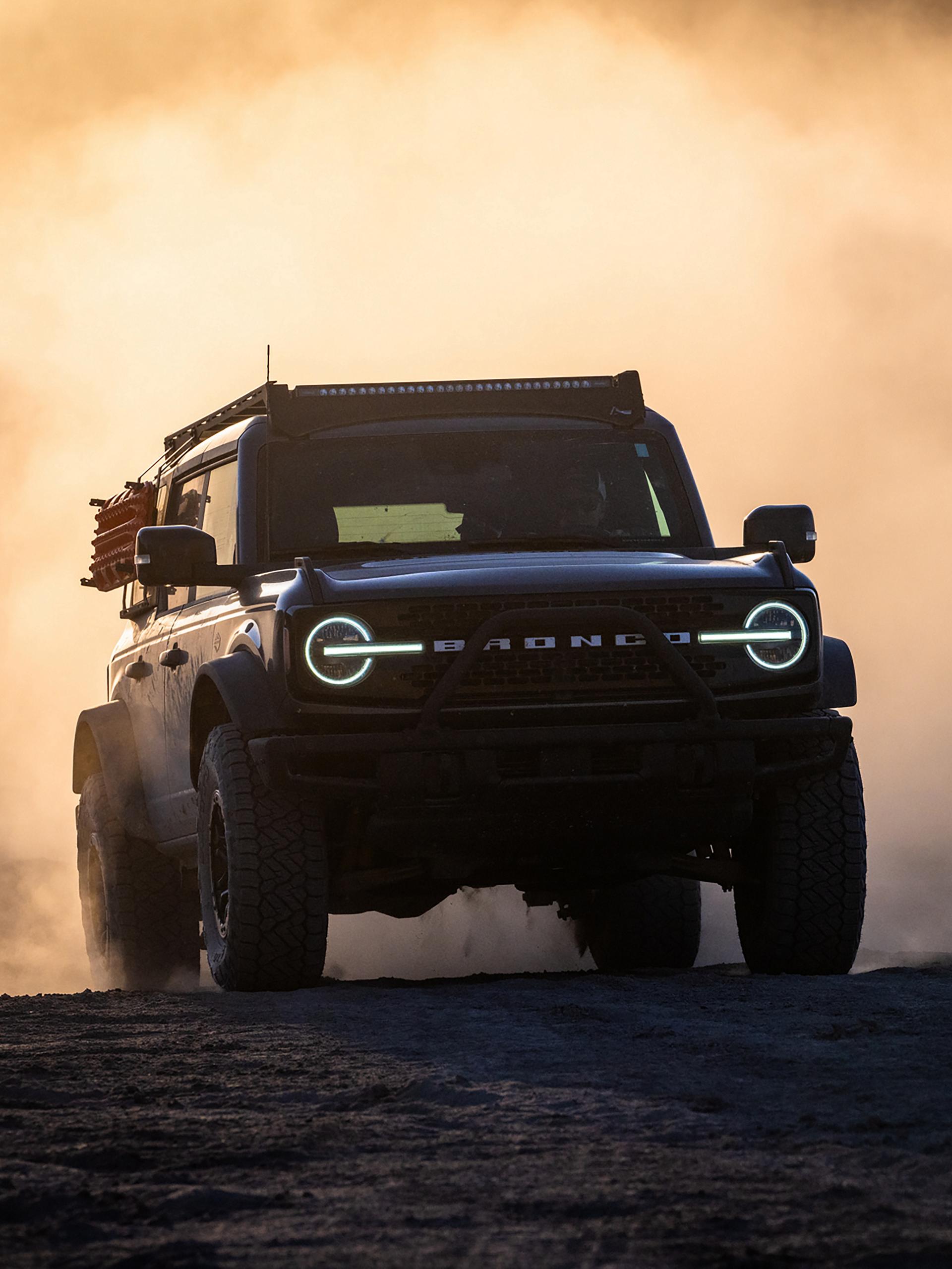 2024 Ford Bronco® WildTrak® driving through dust at sunset