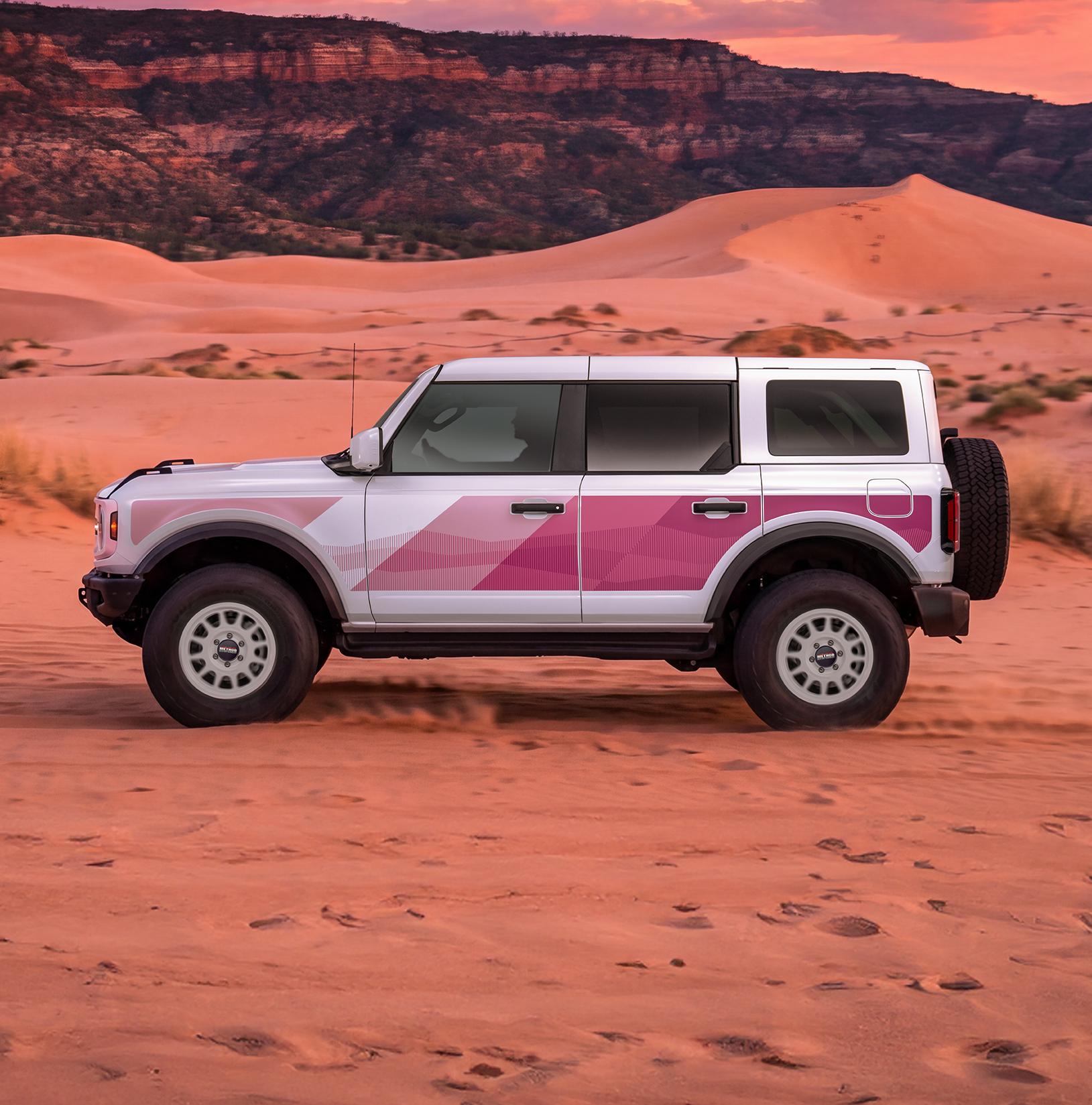Driver-side profile of the white Bronco with pink bodyside graphics
