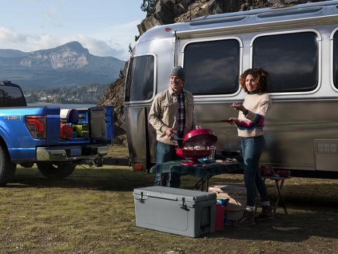 A 2024 Ford F-150® Lariat pickup parked with a camper hooked up