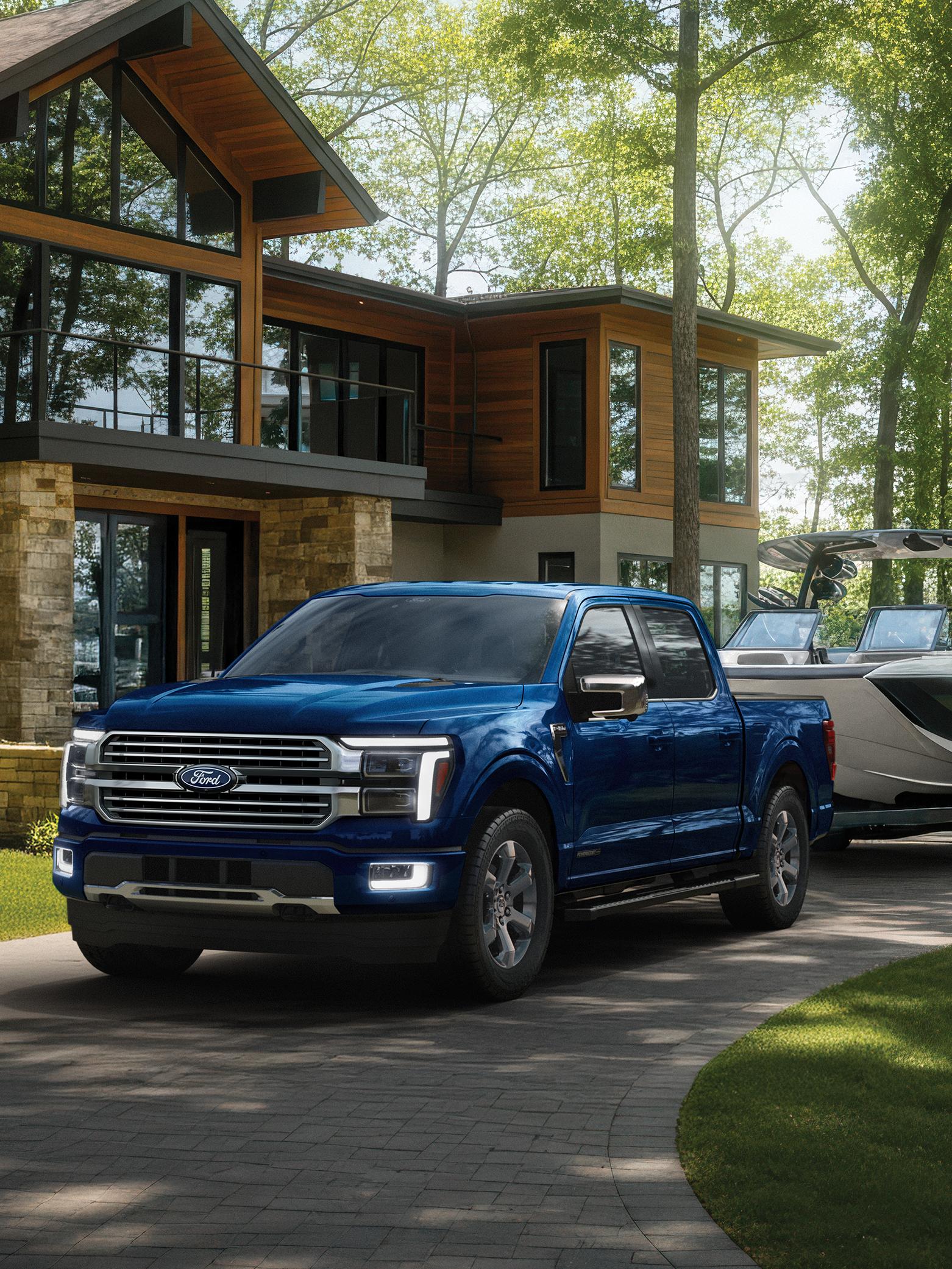 2027 Ford F-150® Platinum® model with the Satin Package pulling a small trailer on a country road