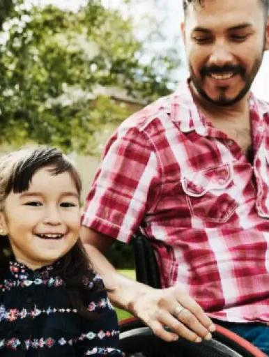 Man in wheelchair sitting beside a child