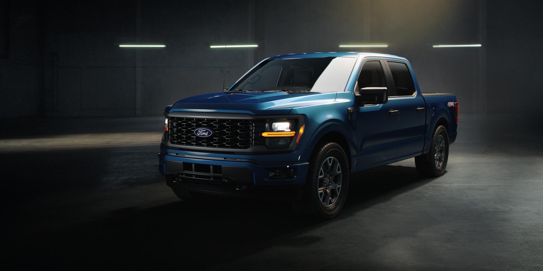 A blue 2025 Ford F-150 truck sitting in a warehouse environment with dramatic lighting.