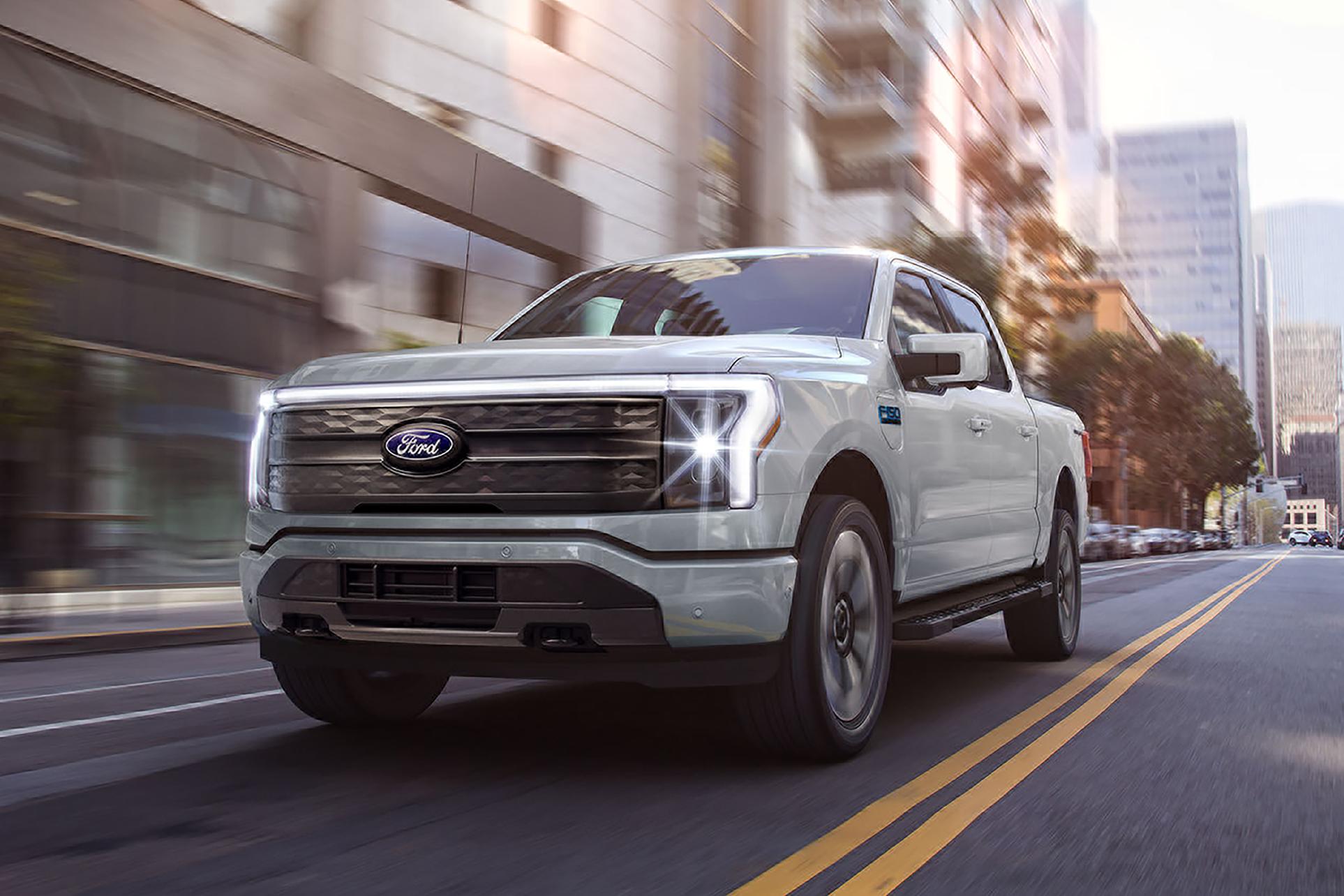 A 2025 Ford F-150® Lightning® pickup being driven down a city street