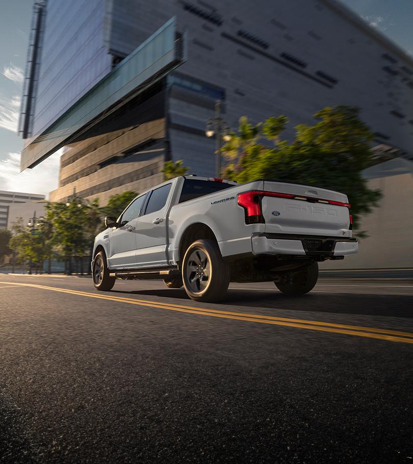 Ford F-150 Lightning driving down road through city