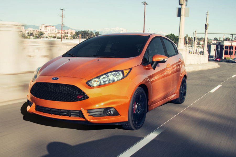 An orange Ford Fiesta driving on the road