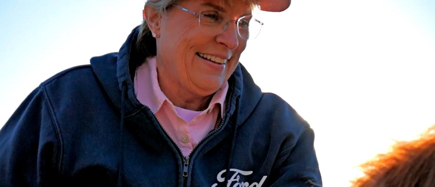 Woman on a horse in a Ford jacket