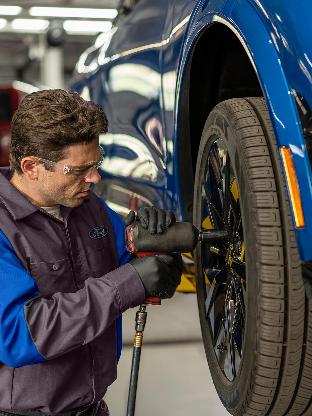 A Ford Service technician tightens up a wheel on a Ford vehicle