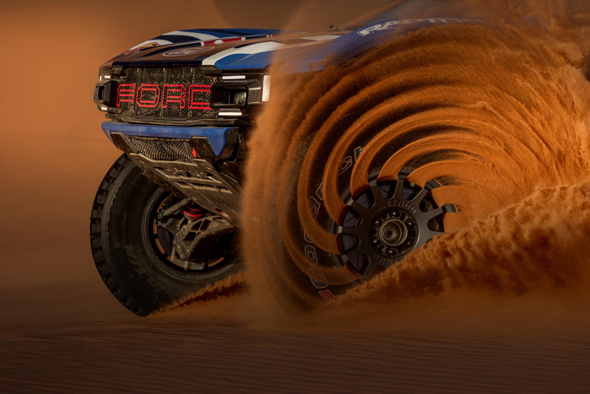 A competition Ford Raptor T1+ kicking up sand in the Dakar Rally