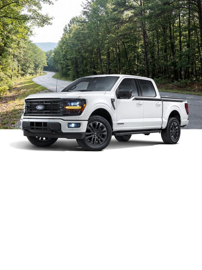 White Ford F-150® truck with the Tennessee Package, with a wooded mountain road background