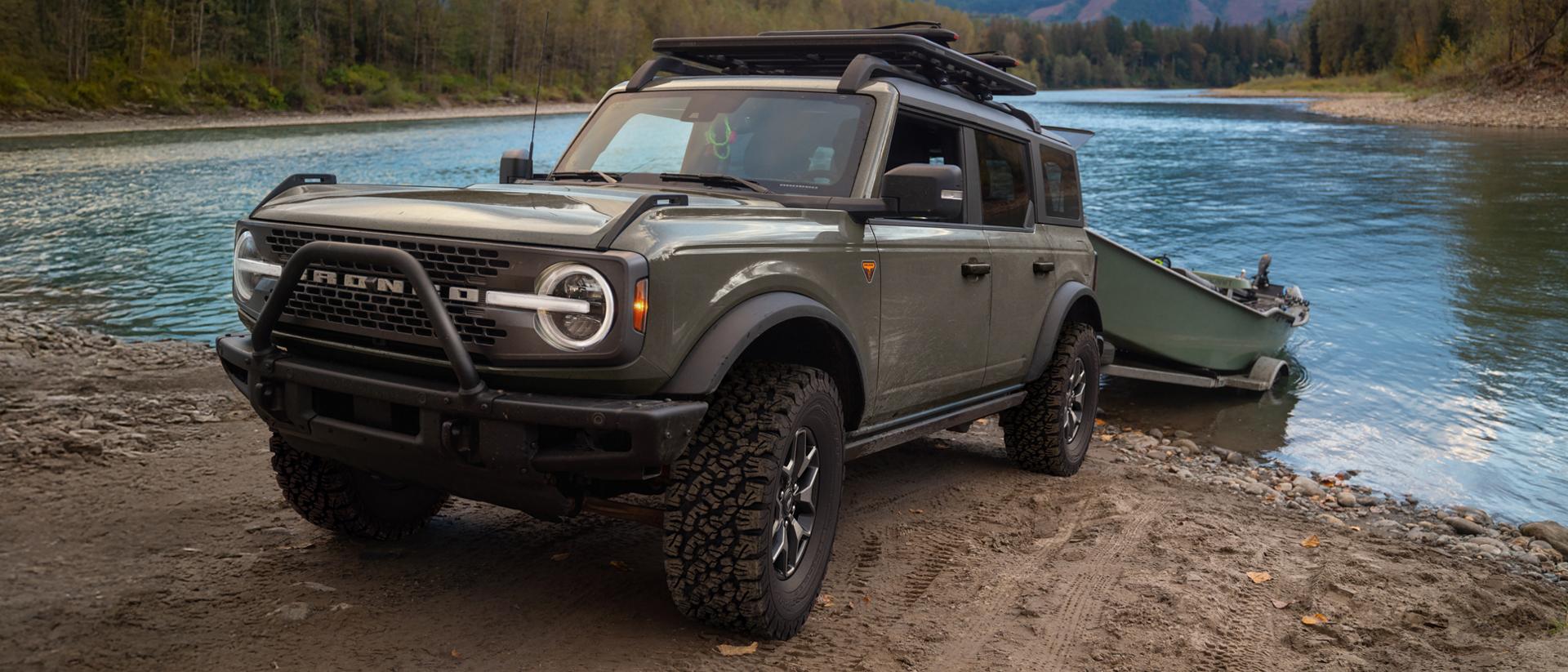 A 2026 Ford Bronco® SUV pulling a boat on a trailer out of a lake