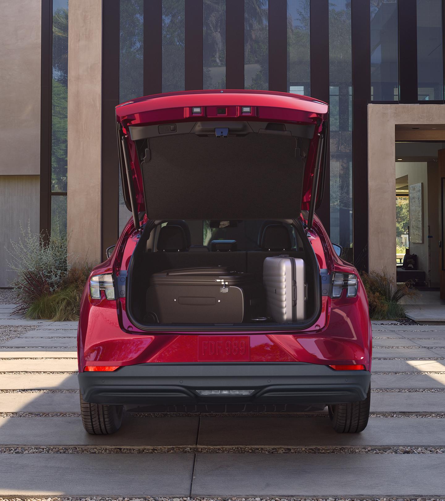 Cargo space of a 2025 Ford Mustang Mach-E® parked in the driveway of a luxury home