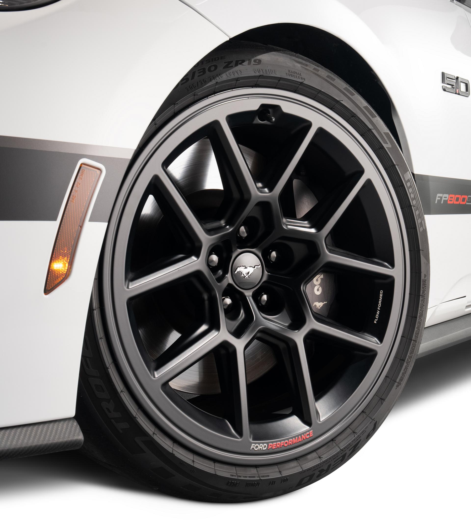 Driver-side front black R1 wheel on the white Mustang