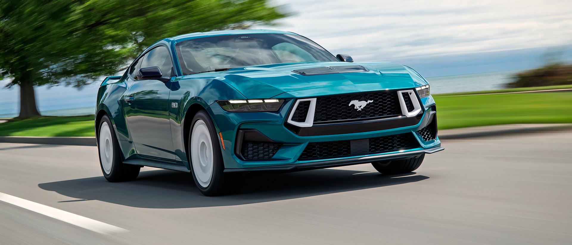 A 2026 Ford Mustang® GT Premium with the available Mustang FX® Package being driven near a lake