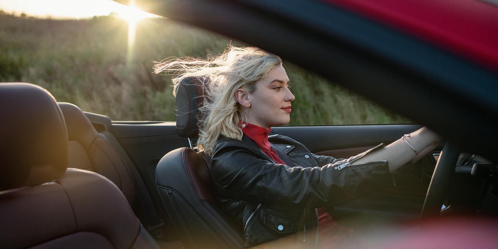 Person driving a 2026 Ford Mustang® GT convertible on a highway