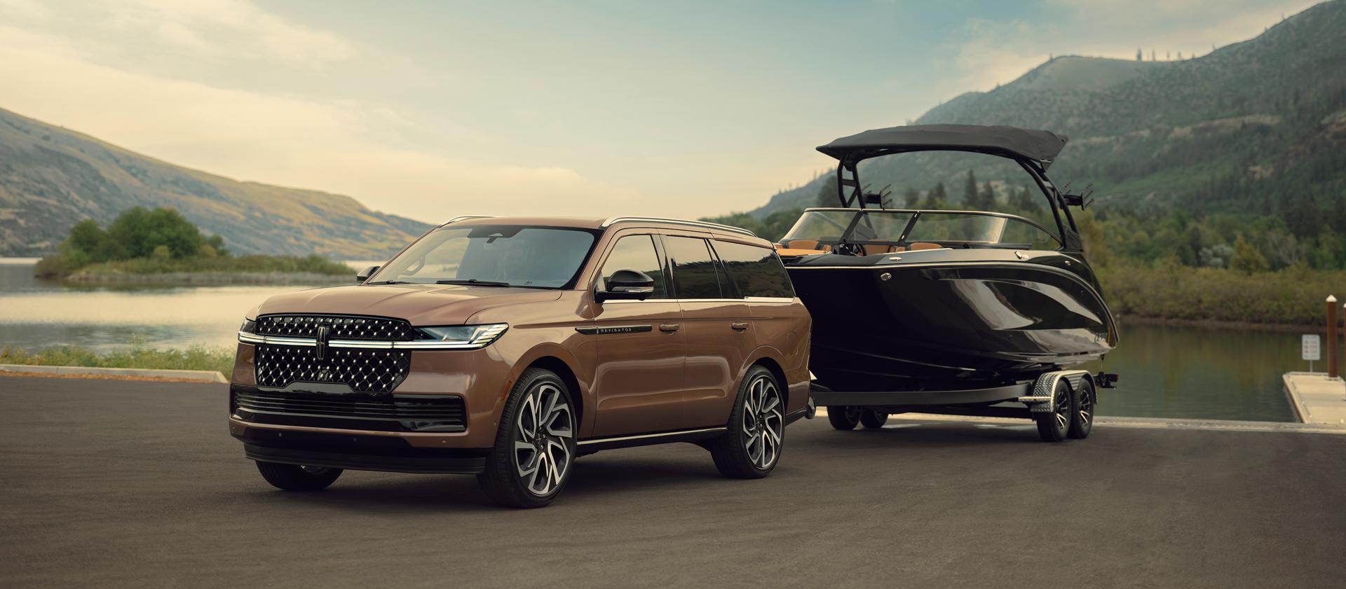 A 2026 Lincoln Black Label Navigator® has a boat hitched up by the water